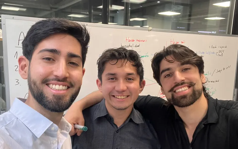 Los tres socios de AIM trabajando frente a una pizarra